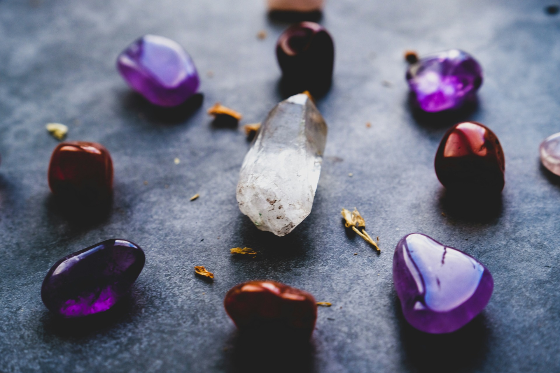 “Cristales esotéricos como cuarzo, amatista y piedras rojas utilizados en rituales de sanación y limpieza energética”.